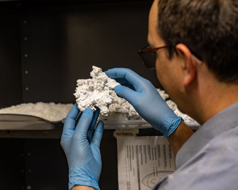 A Cal Poly Pomona engineering student examining a block of waste salt.