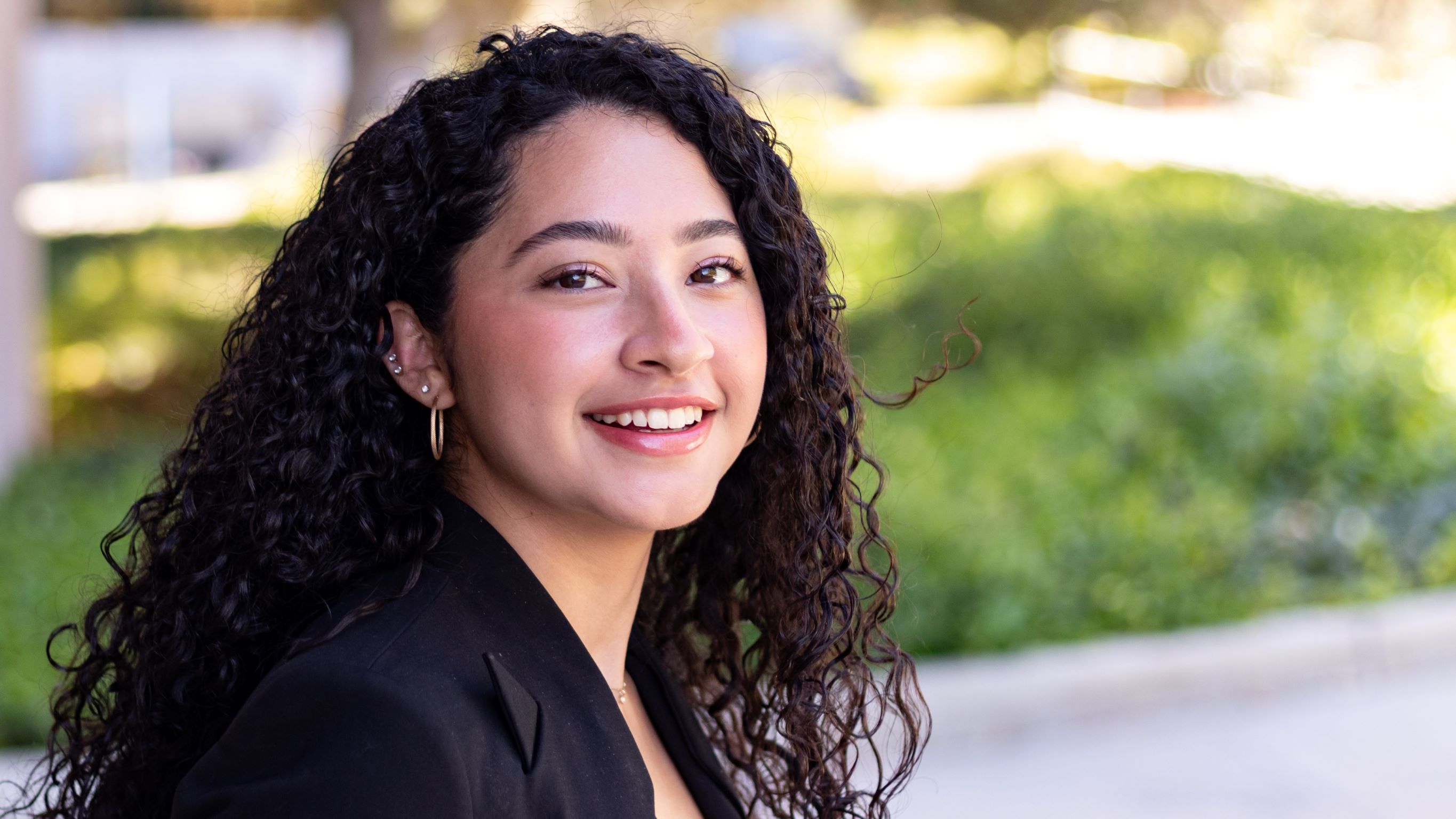 A female engineering student turned towards the camera and smiling.