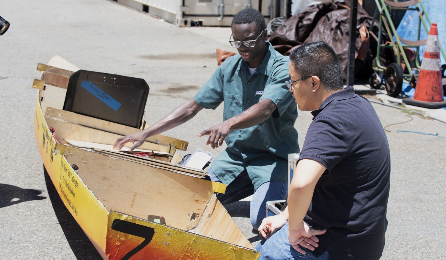 Two students working on a solar boat.
