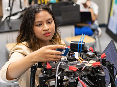 An engineering student working on an unmanned aerial vehicle (UAV).