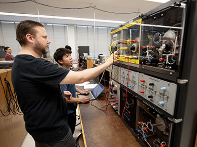 Electrical engineering students working with a device.