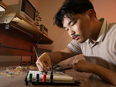 An engineering student working on a breadboard