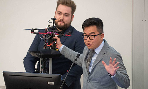 Two male students presenting their engineering project.