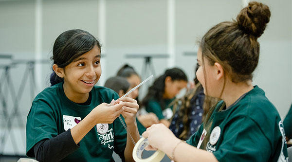 Two middle school girls working on a project.