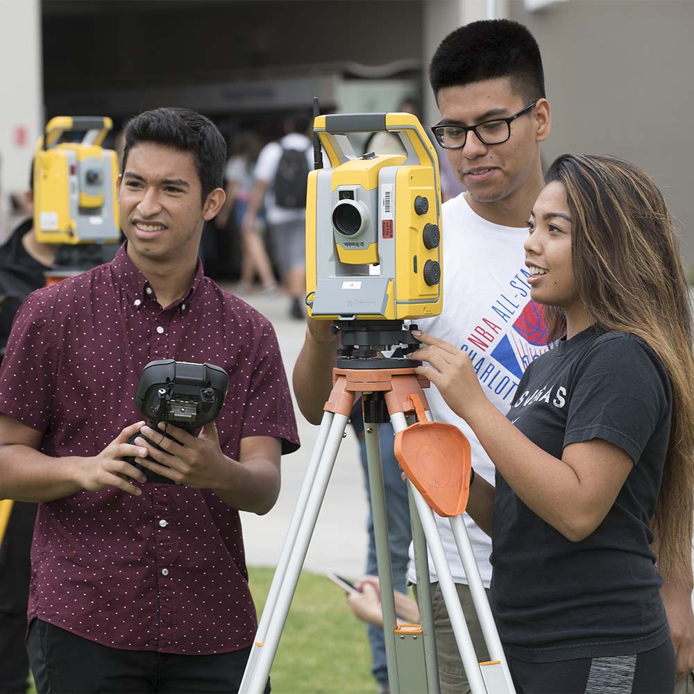 A group of students using a surveying tool at Cal Poly Pomona