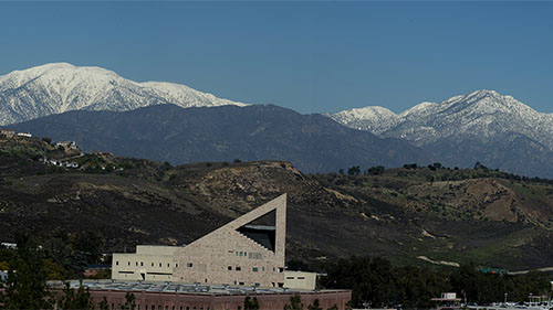 CPP's CLA building in the foreground with distant mountains in the background at CPP.