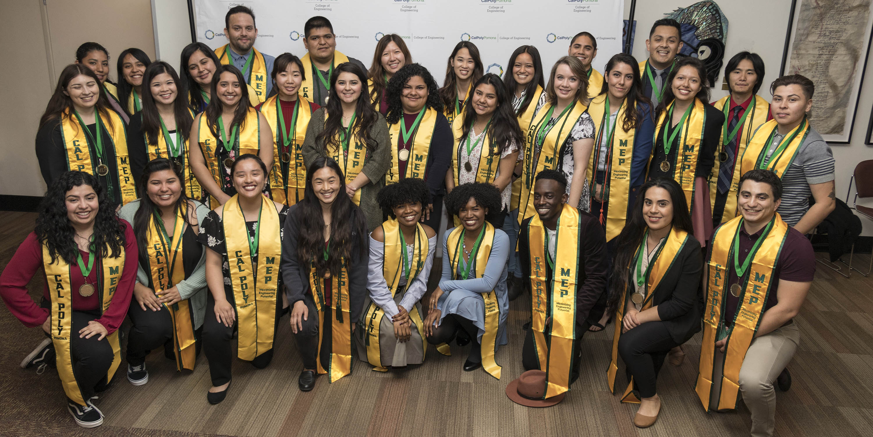 A group of college students with their graduation cords and sashes.