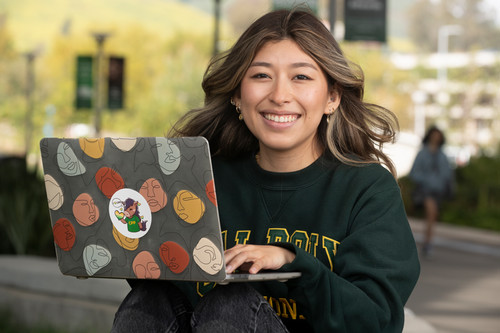 Student with laptop smiling
