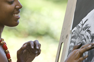 A student completes her charcoal artwork outside Building 13