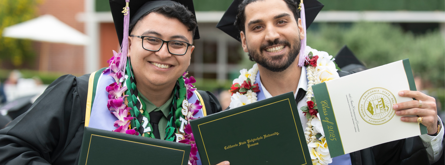 Two students smile at graduation