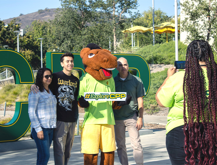 A group of students pose with Billy Bronco in front of letters that spell "CPP" at Explore CPP