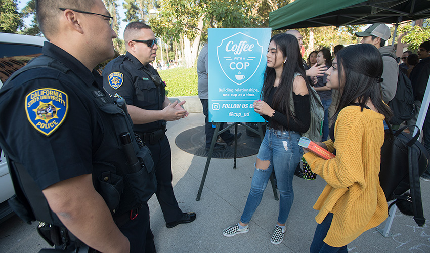 A staff member shakes a CPP police officer during coffee with a cop.