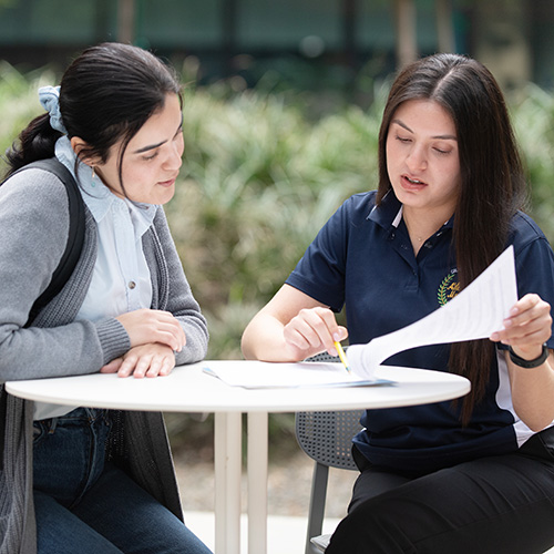 A female advisor speak with a female student outside of the SSB. 