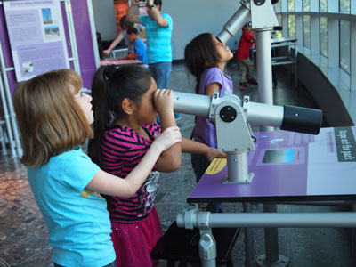 Children looking through a telescope