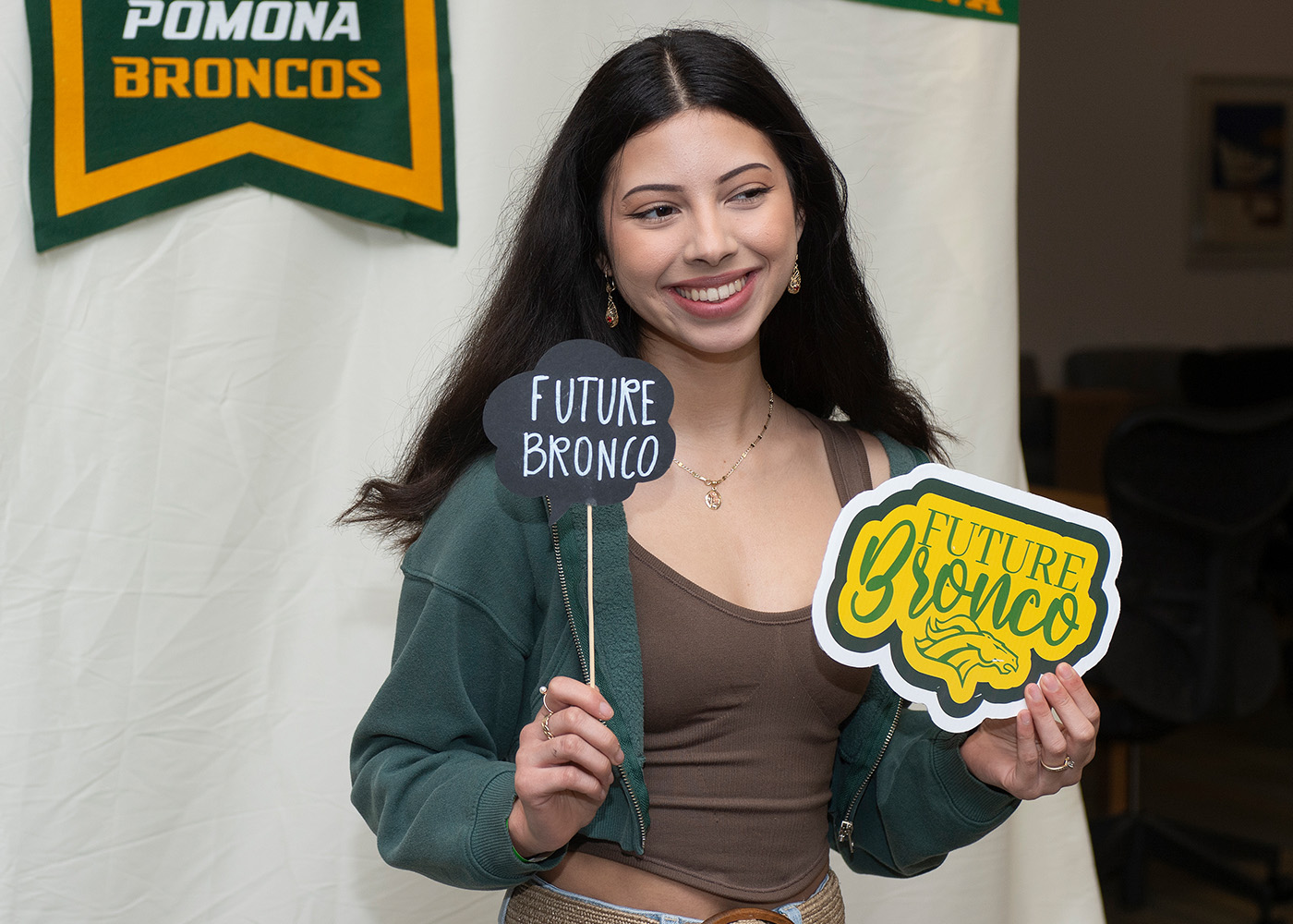 A prospective student holding up a "Future Bronco" sign