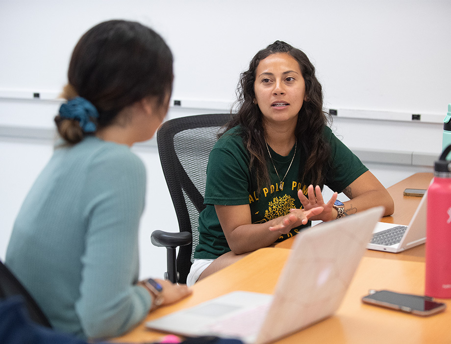 student talking to another student in a classroom