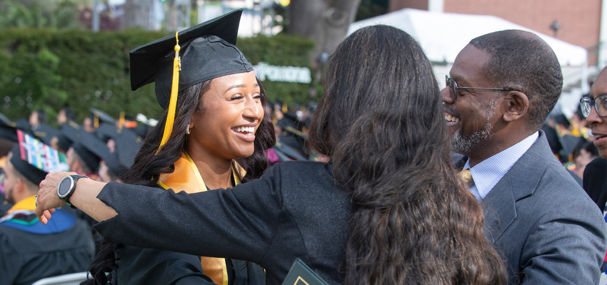A graduate celebrating with family
