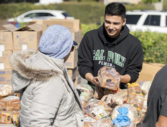 CPP student helps distribute bread during a Sowing Seeds For Life Food Pantry