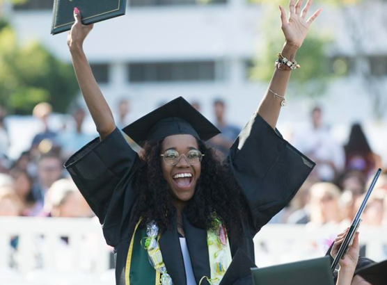 a graduate student celebrating with hands in the air