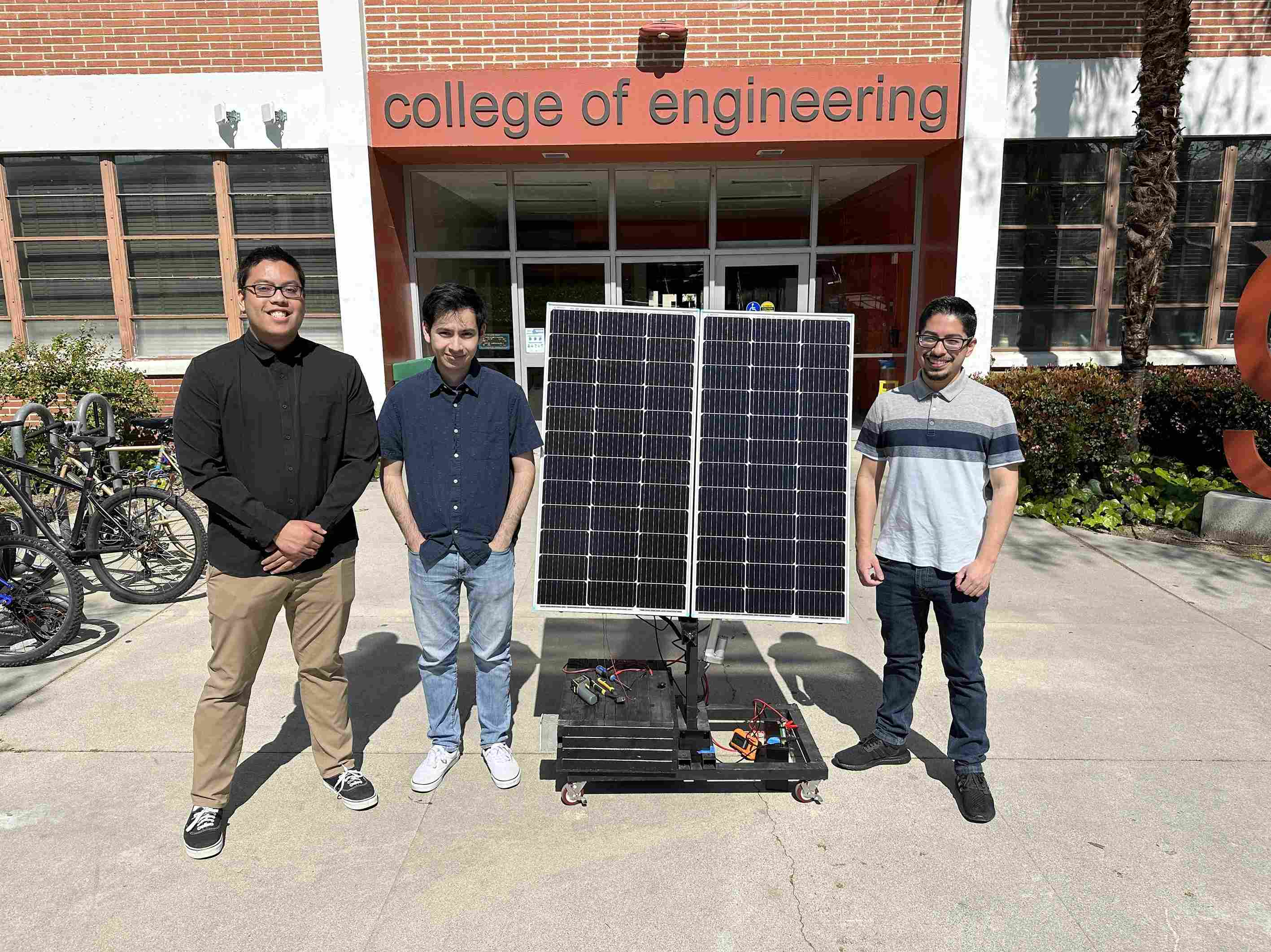 The three members of Solar Trackers with a solar panel.