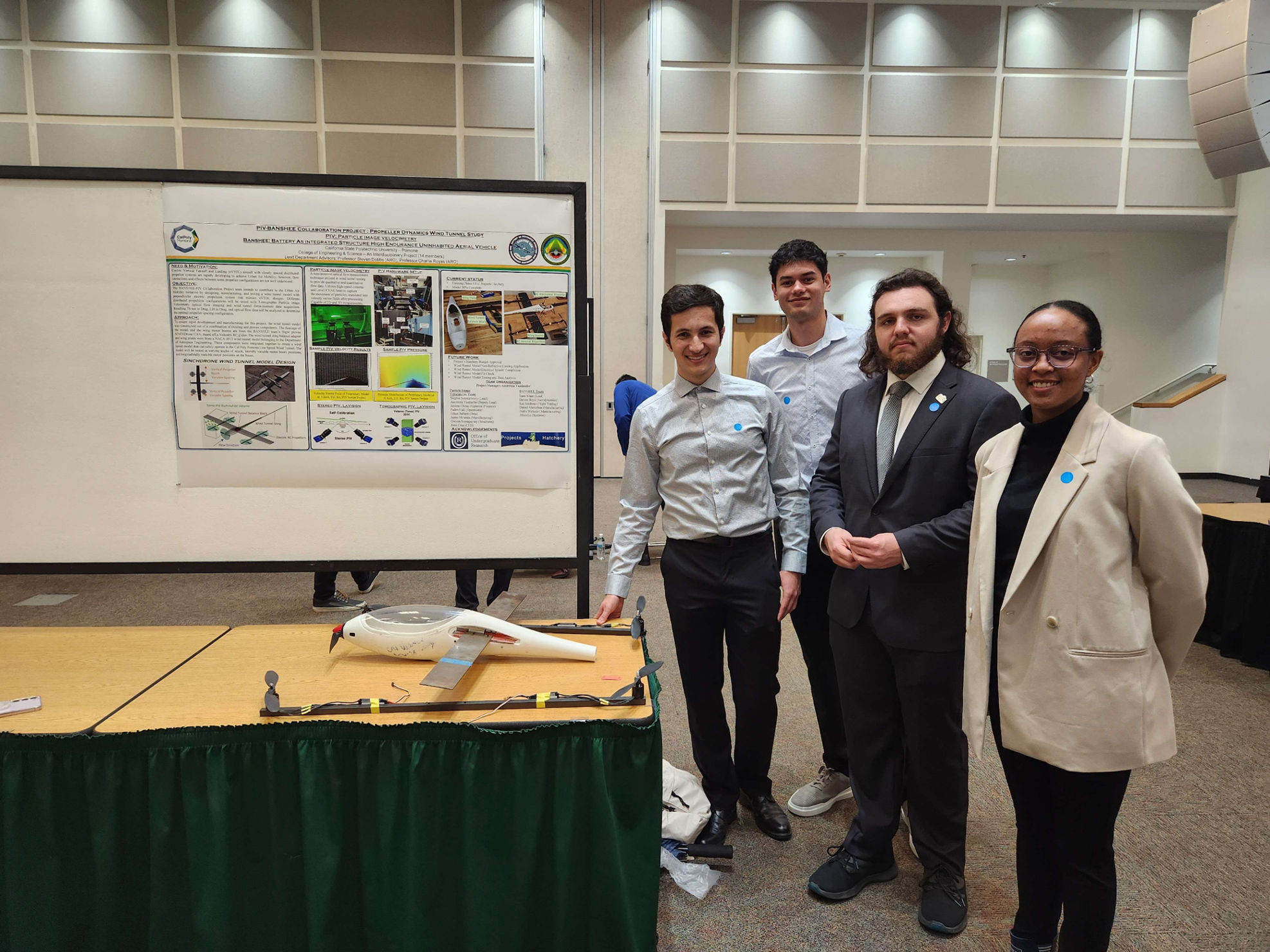 Team PIV posing with their research poster.