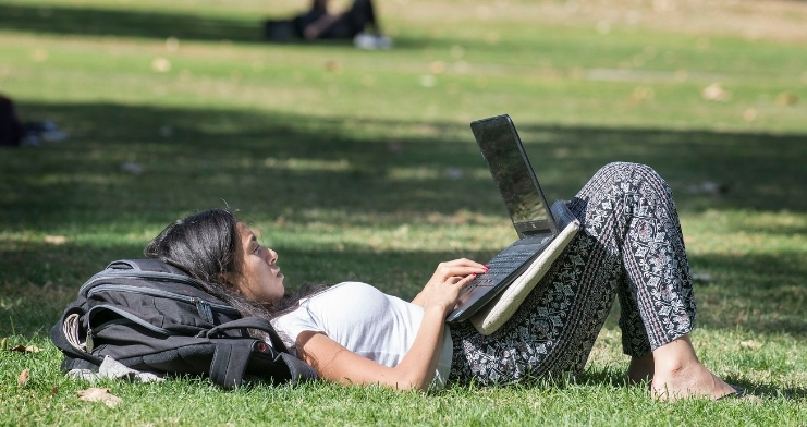A student studies on their laptop in the Quad