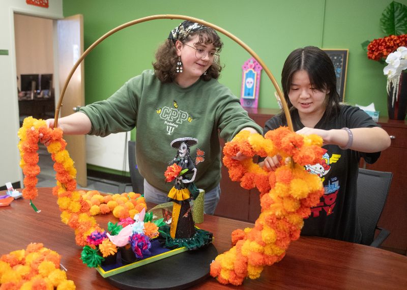 CPP students applying marigolds to a basket for a civic event