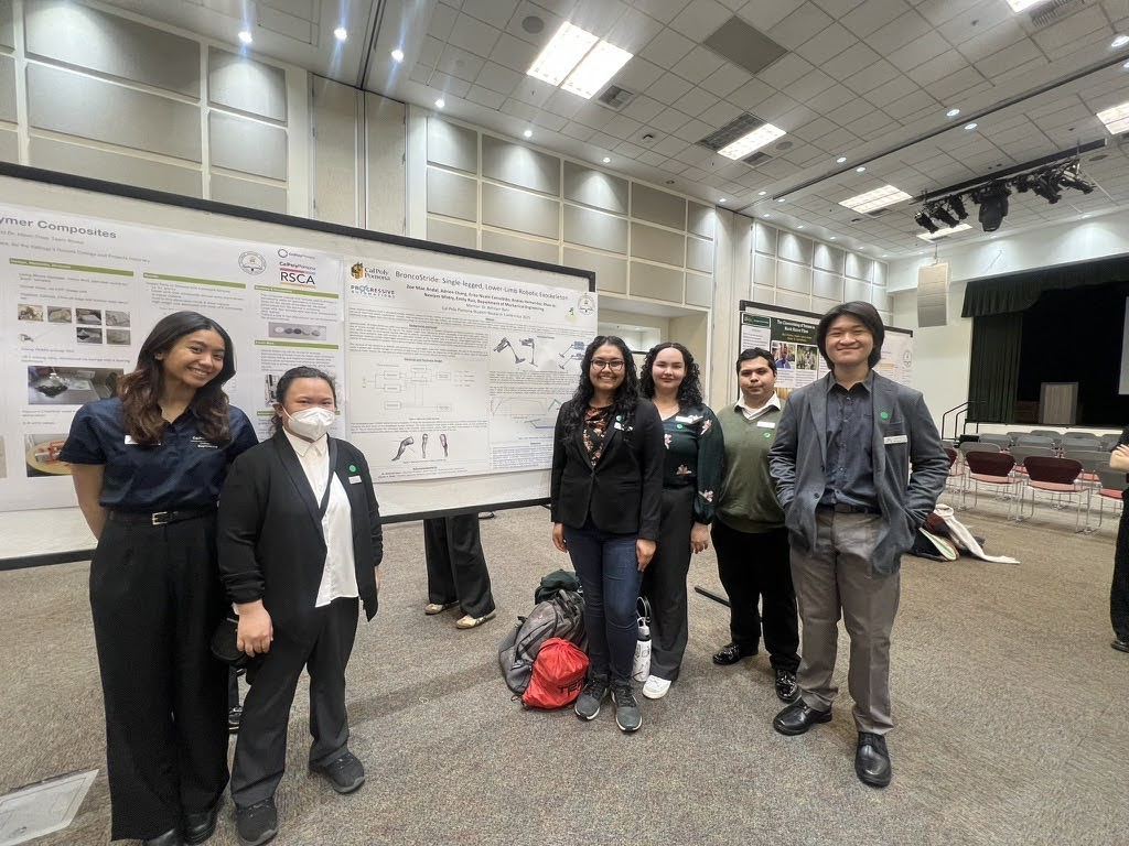 A group of students standing in front of a research poster