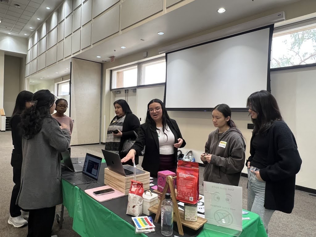 Group of people talking at a table with stuff on it