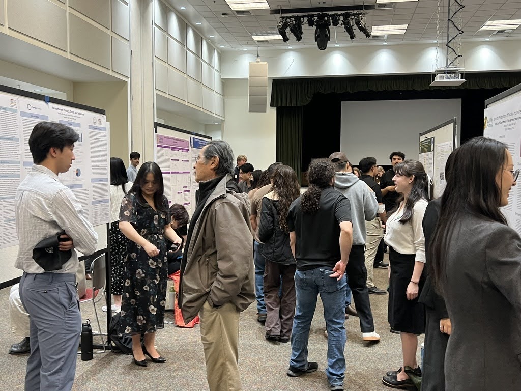 Crowd of people talking near research posters