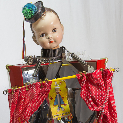 Gina M.  The Big Show from the Toy Box Kids Series, 2018  assemblage, convex mirror shards, toys, step stool, toy tires, curtain and hardware  68 x 24 x 24”  Courtesy of the artist