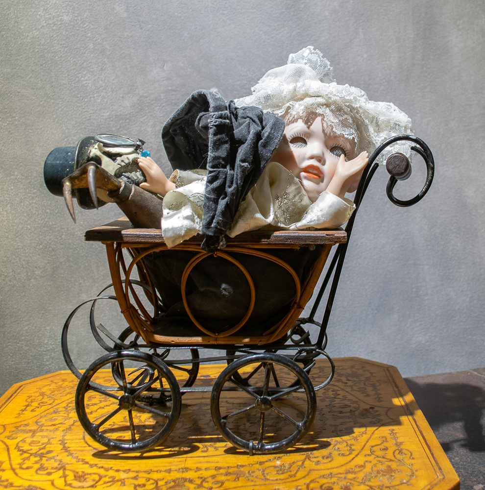 Gina M.  Mawwiage from the Toy Box Kids Series, 2017  assemblage, doll head, clay skull, toy carriage, tray, doll clothes, displayed on vintage trunks  12 x 15 x 12”  Courtesy of the artist