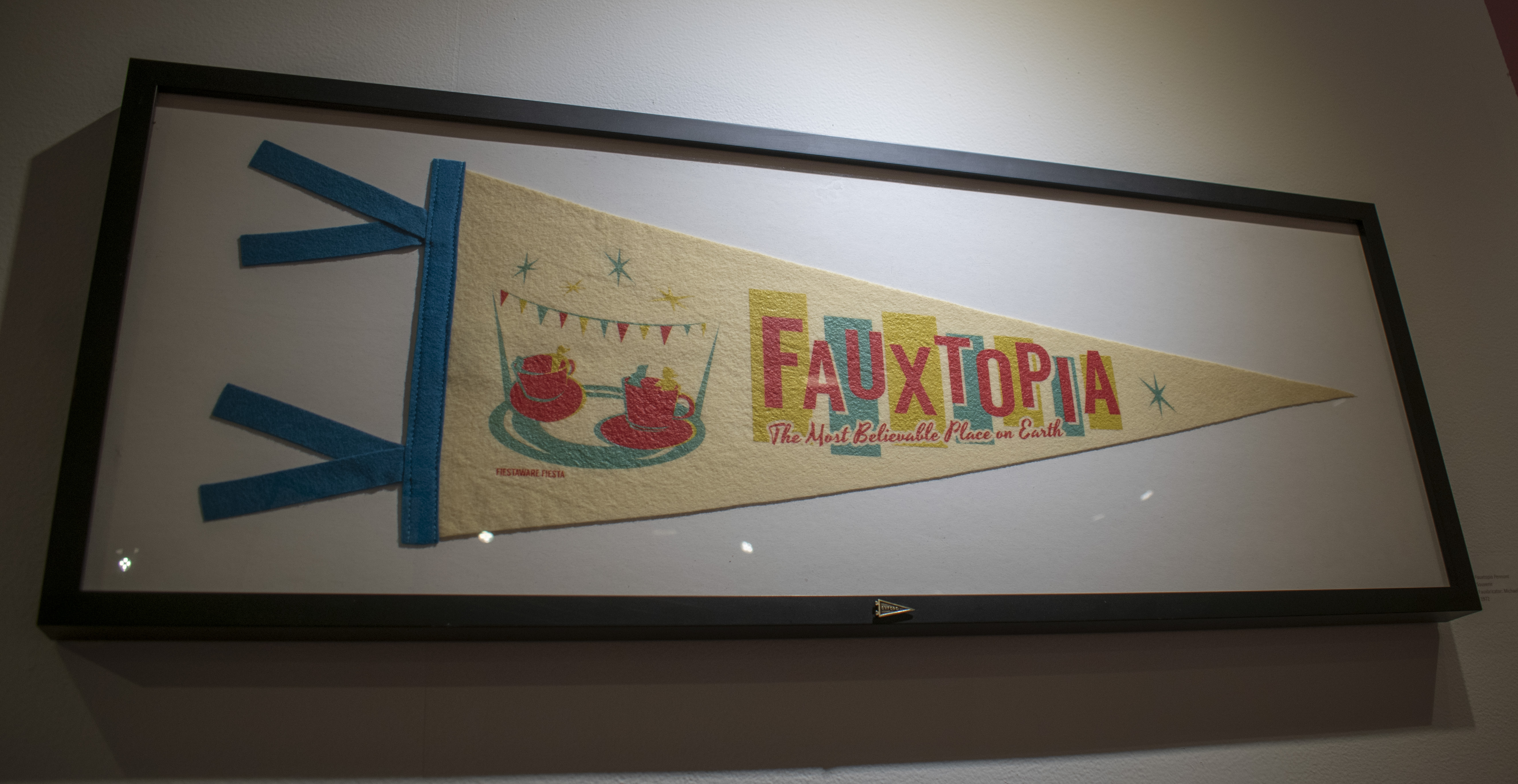 Multi Colored Pennant with teacup amusement ride with Fauxtopia title "Fauxtopia The Most Beautiful Place on Earth"
