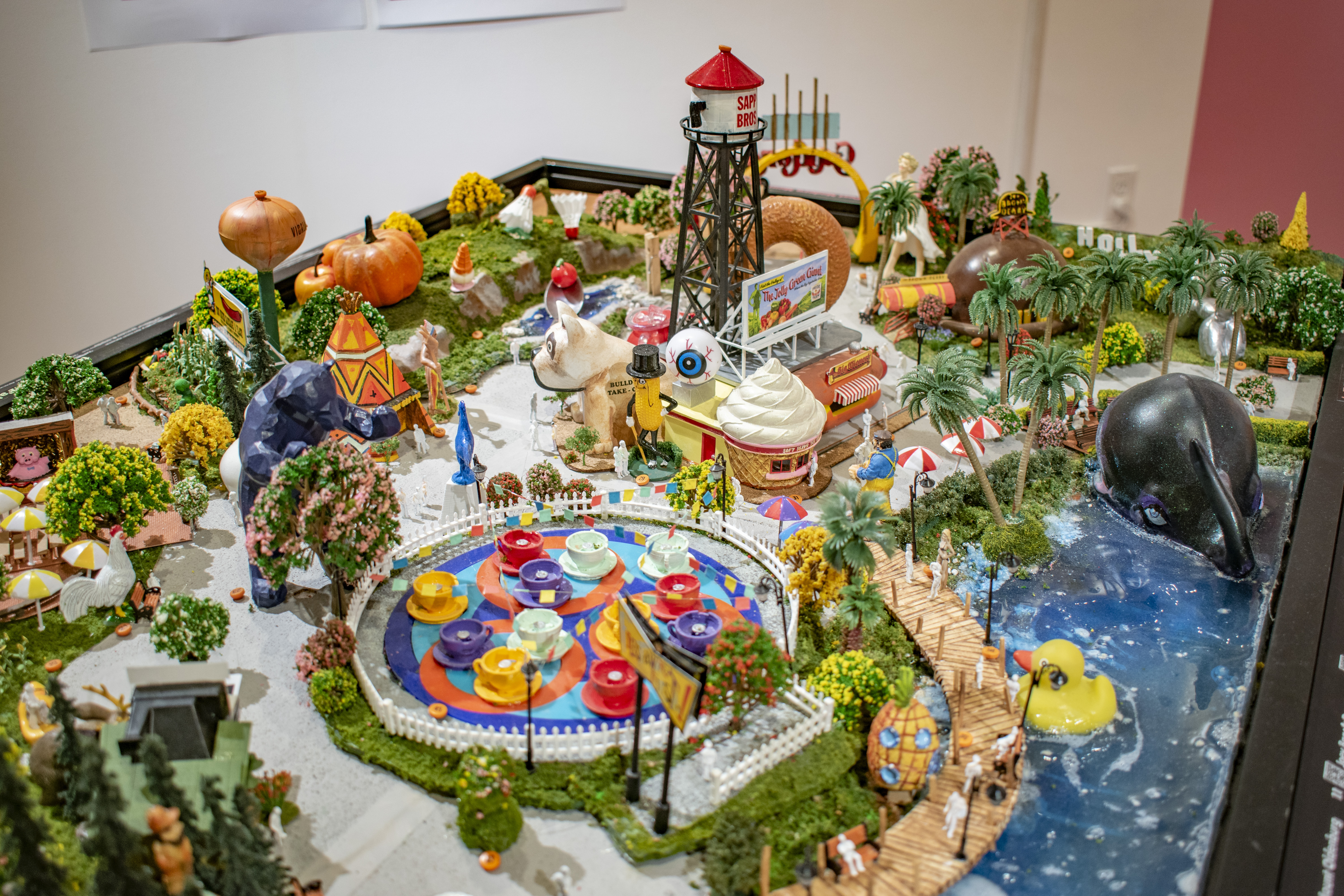 Display model of theoretical amusement park with rides, and sculptures related to Fauxtopia theme