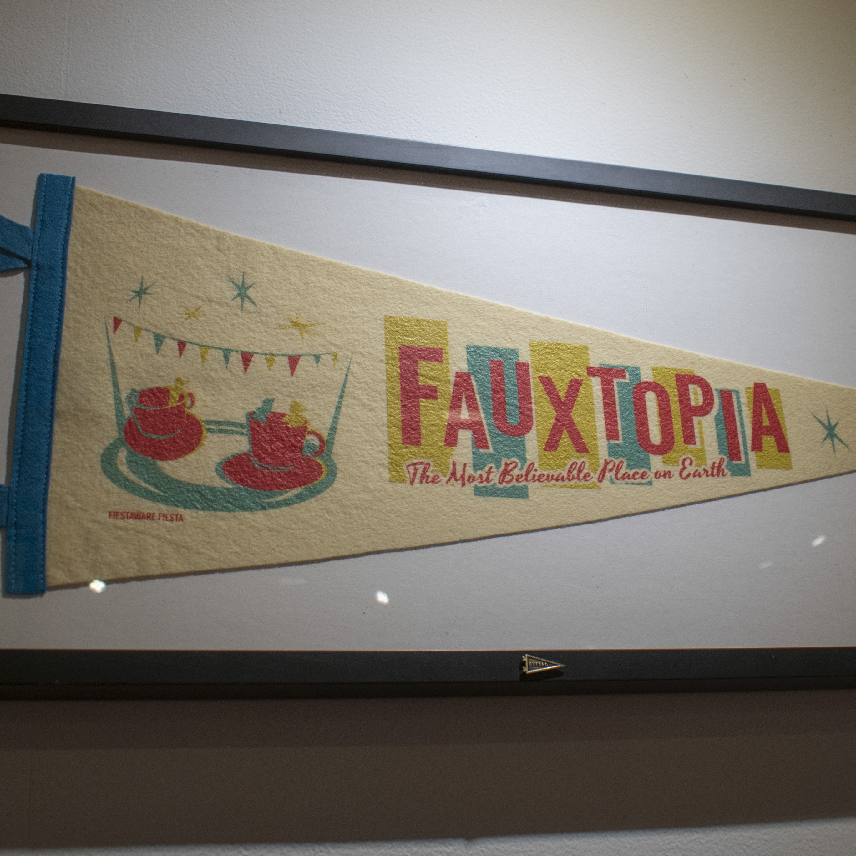 Multi Colored Pennant with teacup amusement ride with Fauxtopia title "Fauxtopia The Most Beautiful Place on Earth"