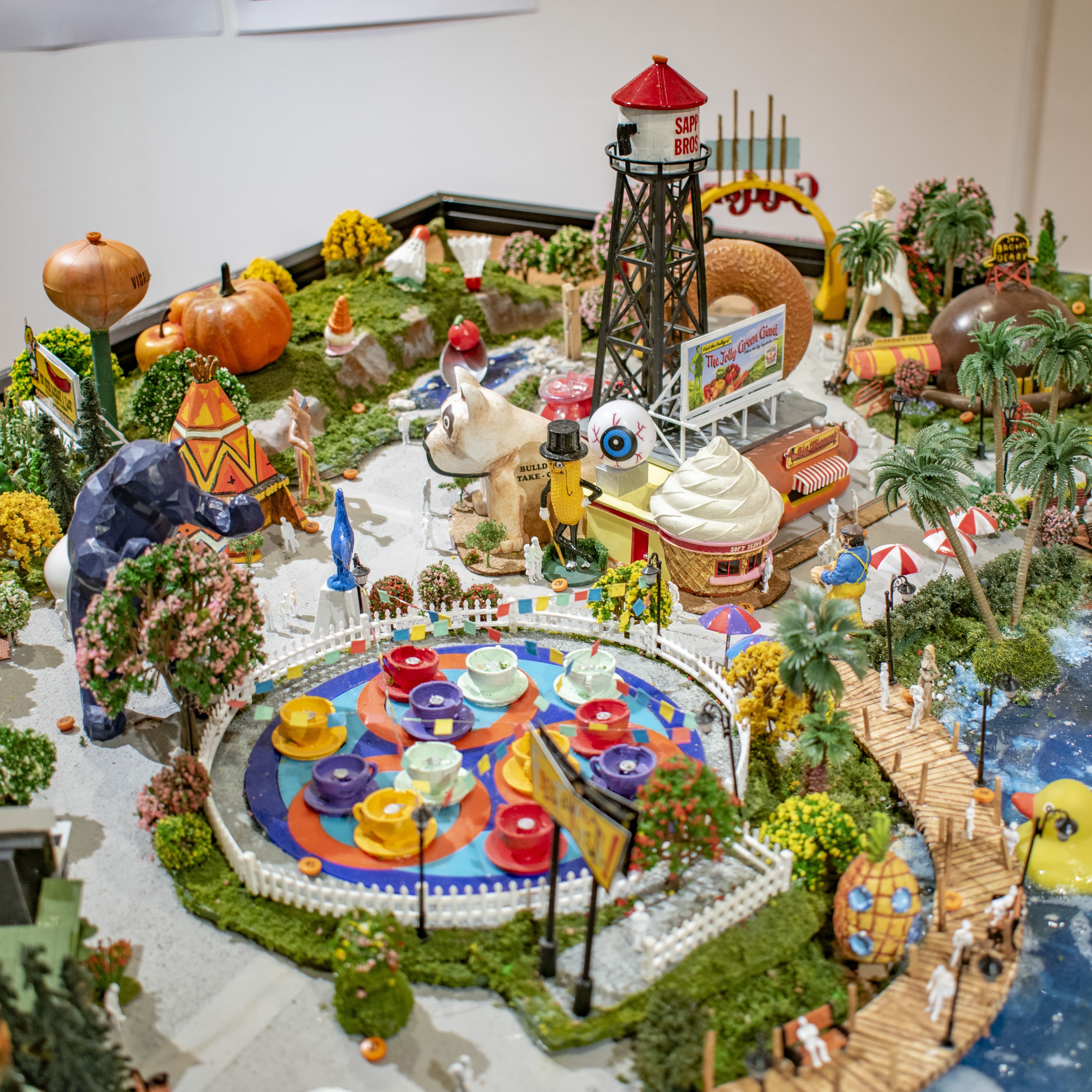 Display model of theoretical amusement park with rides, and sculptures related to Fauxtopia theme