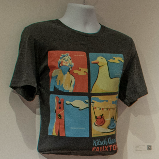 T-shirt with Marilyn Monroe, Duck, Clothespin Sculpture, and Teacup ride graphics and text "Kitsch Gardens Fauxtopia" 