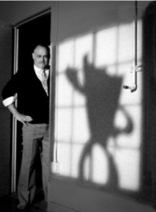 Image of a man standing next to the shadow of Blank the character 