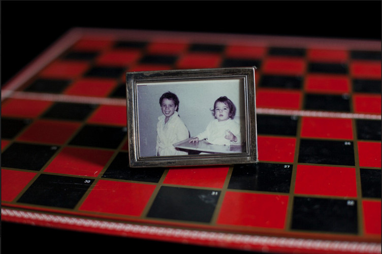 framed photo of siblings on top of a chess board 