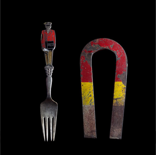 metallic fork with handle as a man next to a used magnet 