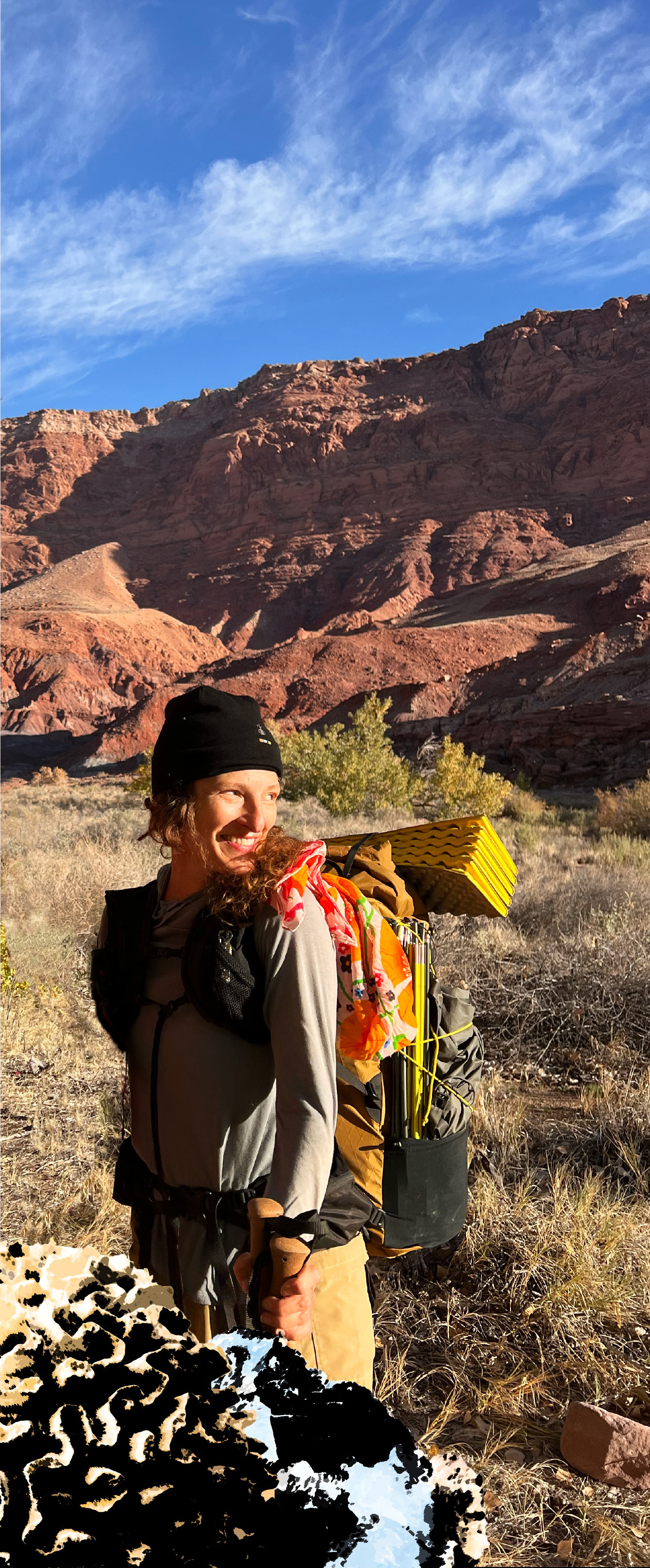 A photograph of Sarah Meyer looking to her left with a mountain like rock formation in the background