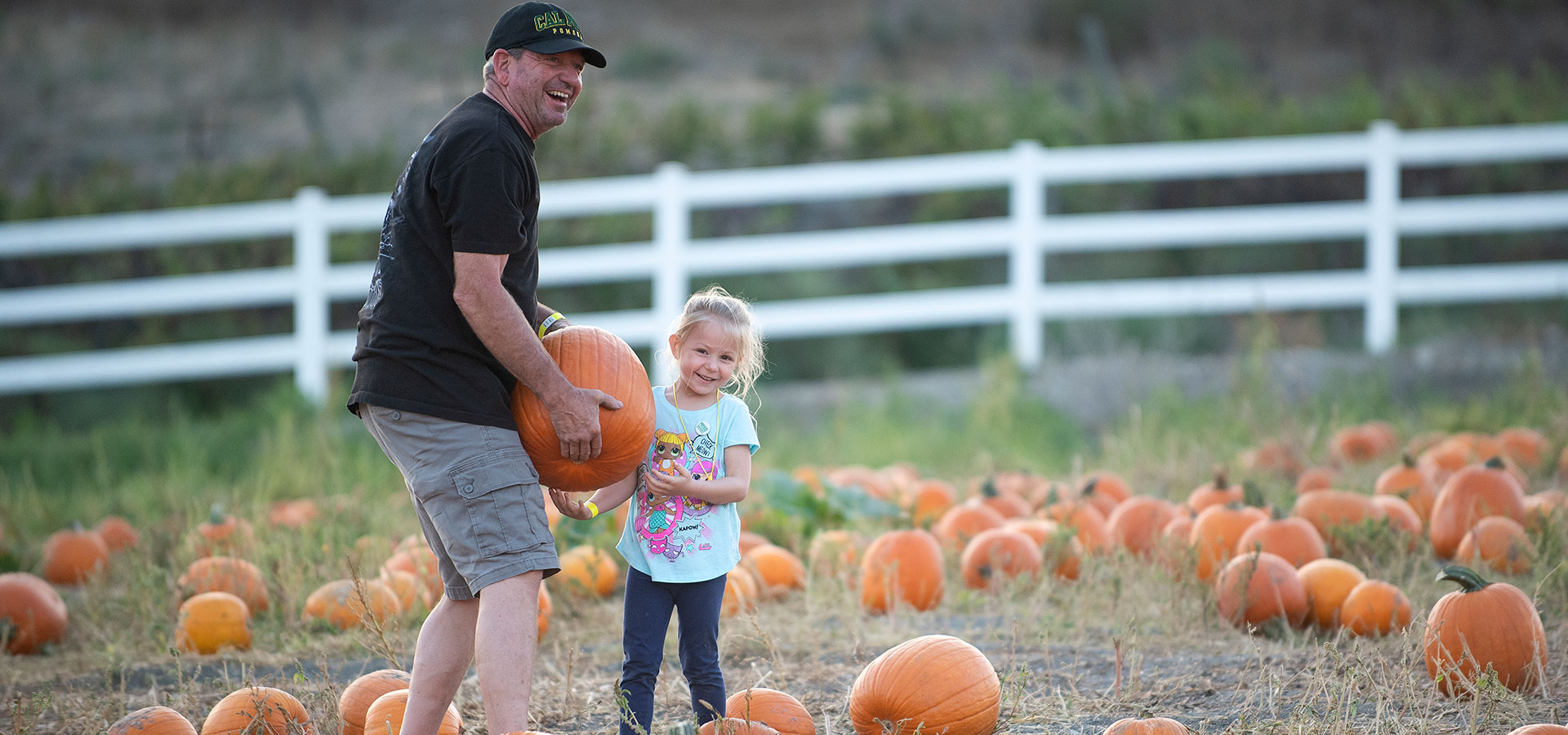 A father and daughter together at the pumpkin patch