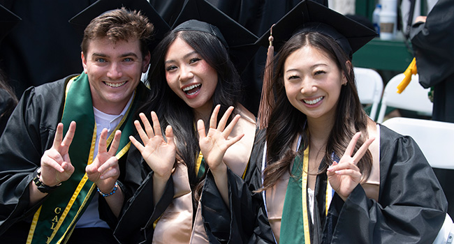 Three CEIS students smile during the 2023 commencement ceremonies.