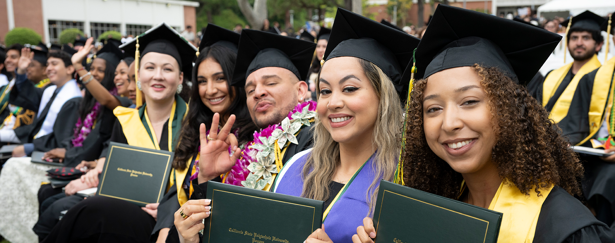 A group of female and male graduates smile during the 2025 commencement ceremonies.