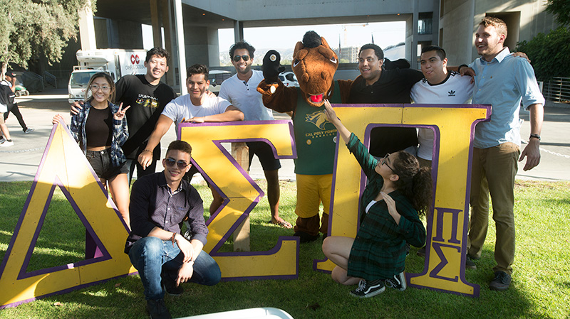 A group of students pose with signage during the 50th anniversary celebration.