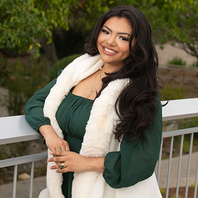 Diana Aguilar-Cruz smiles wearing a boa
