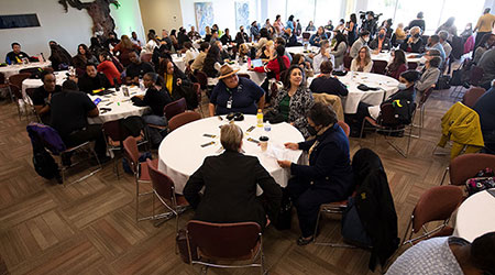 Participants sit at round tables at the Black Thriving Initiative Symposium