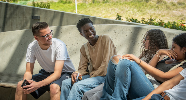 A group of diverse students laughing and talking.