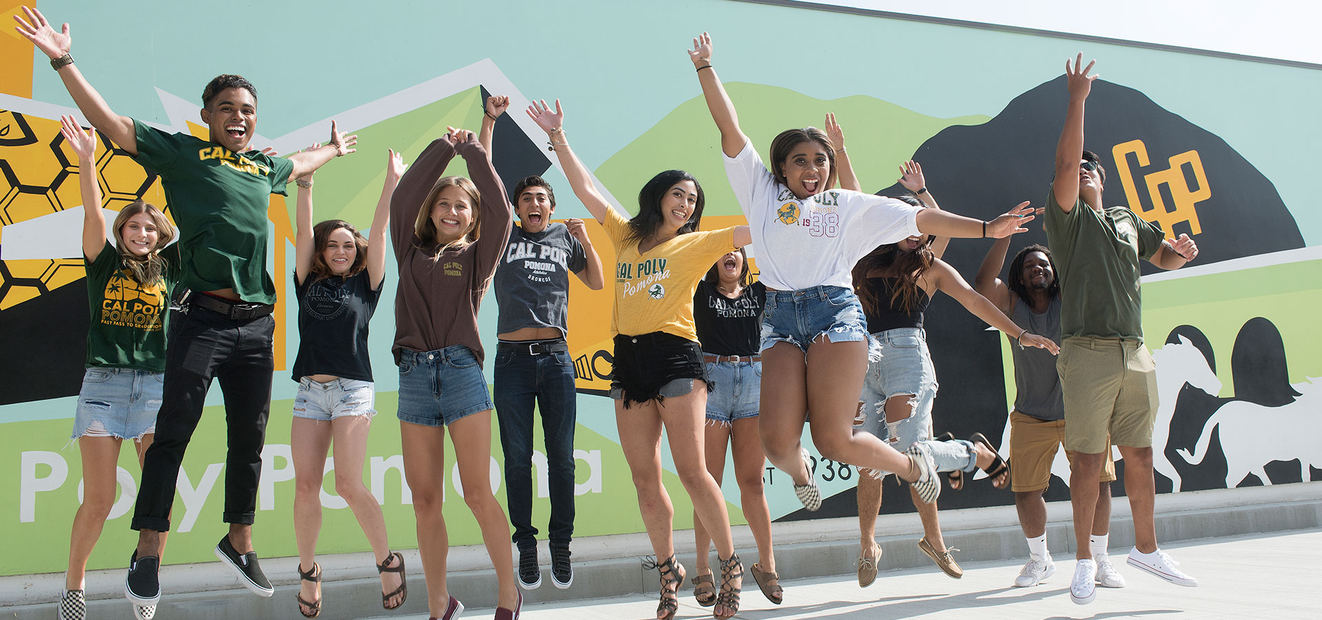 A group of students jumping up at the Parking Structure II Mural