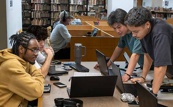 students looking down at a laptop